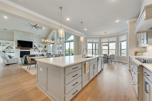 kitchen with a center island with sink, a wealth of natural light, a fireplace, and hanging light fixtures