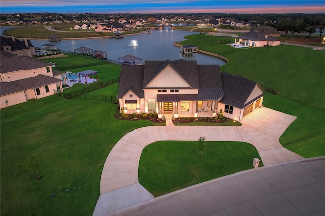 aerial view at dusk featuring a water view