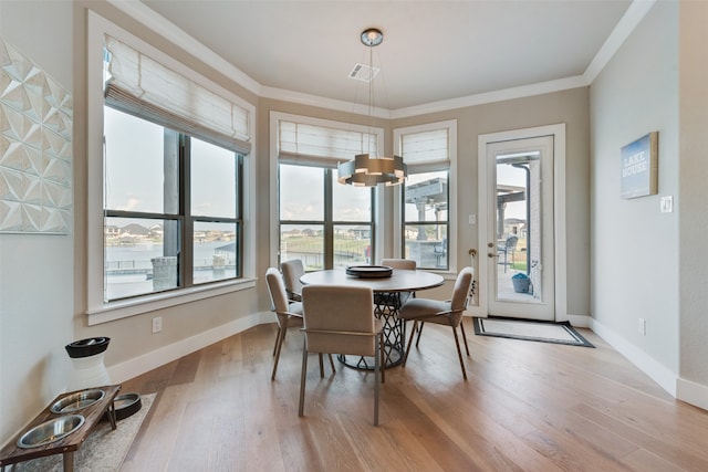 dining space with crown molding, light hardwood / wood-style flooring, and plenty of natural light