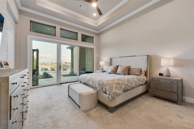 bedroom featuring access to exterior, light colored carpet, a raised ceiling, a towering ceiling, and ceiling fan