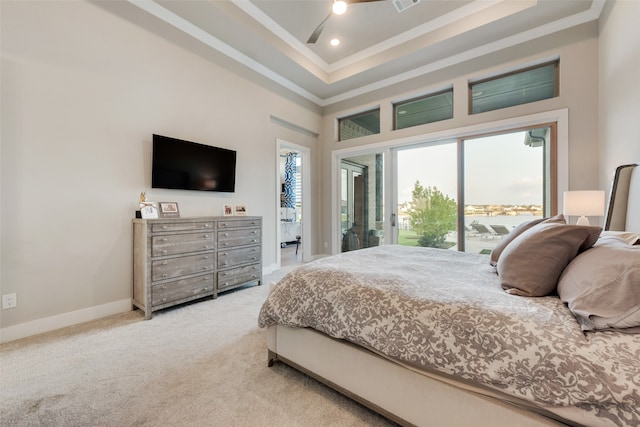 carpeted bedroom with ceiling fan, access to exterior, a tray ceiling, a towering ceiling, and crown molding