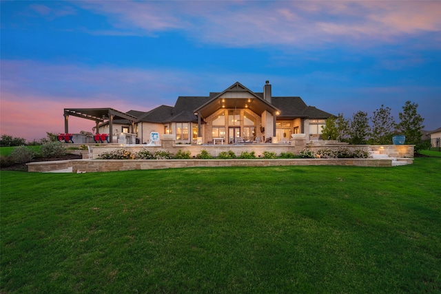 back house at dusk with a lawn