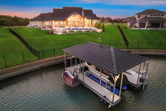 view of dock with a yard and a water view