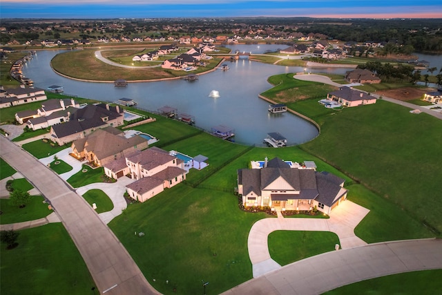 aerial view at dusk featuring a water view