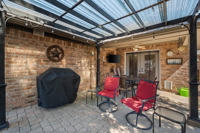 view of patio / terrace featuring area for grilling, a ceiling fan, and a pergola