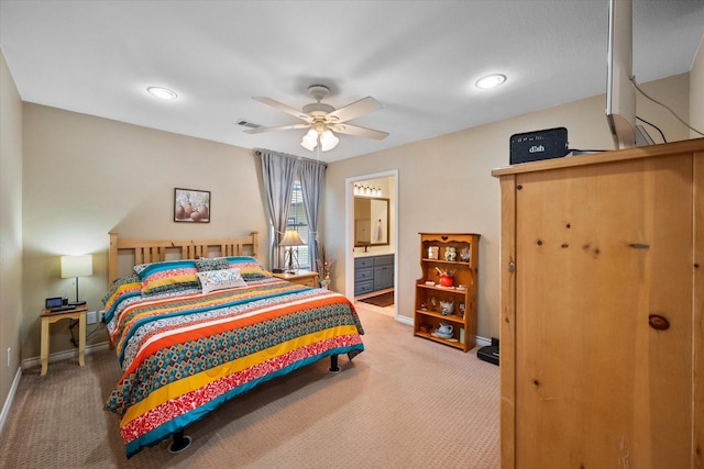 carpeted bedroom with visible vents, ceiling fan, ensuite bath, and baseboards