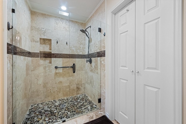 bathroom featuring a stall shower, ornamental molding, and a closet