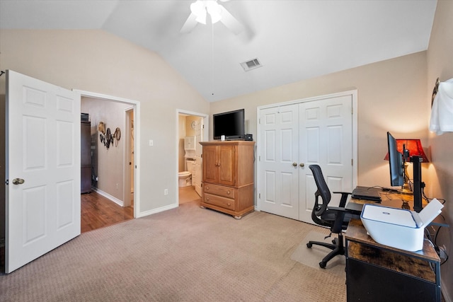 office space with light carpet, baseboards, visible vents, a ceiling fan, and vaulted ceiling