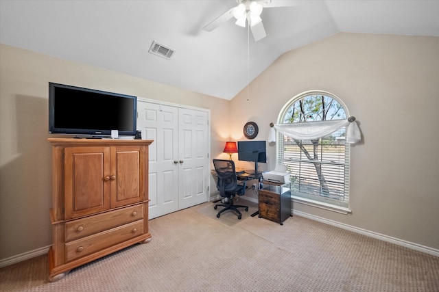 office space featuring light colored carpet, visible vents, vaulted ceiling, ceiling fan, and baseboards