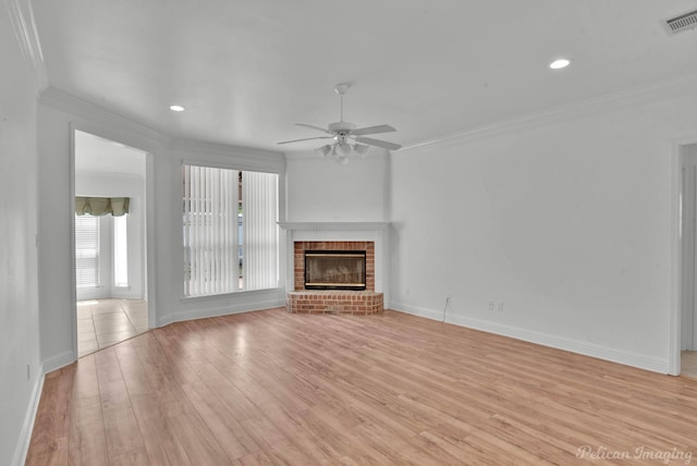 unfurnished living room featuring a fireplace, light hardwood / wood-style flooring, ceiling fan, and crown molding