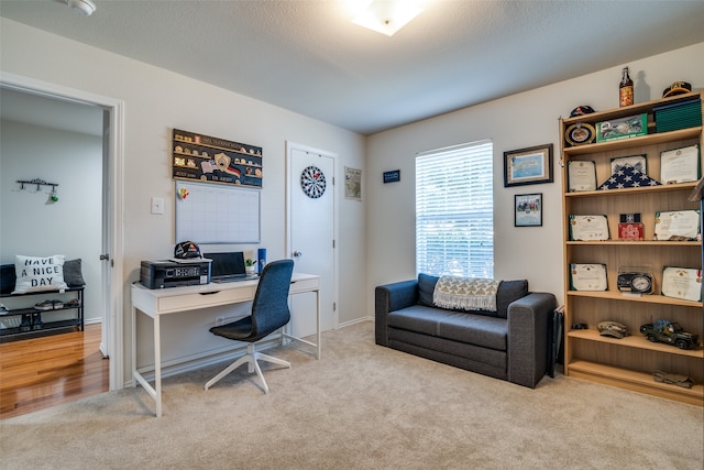 carpeted office featuring a textured ceiling