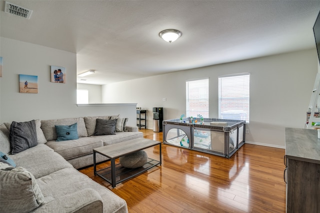 living room with wood-type flooring and a textured ceiling