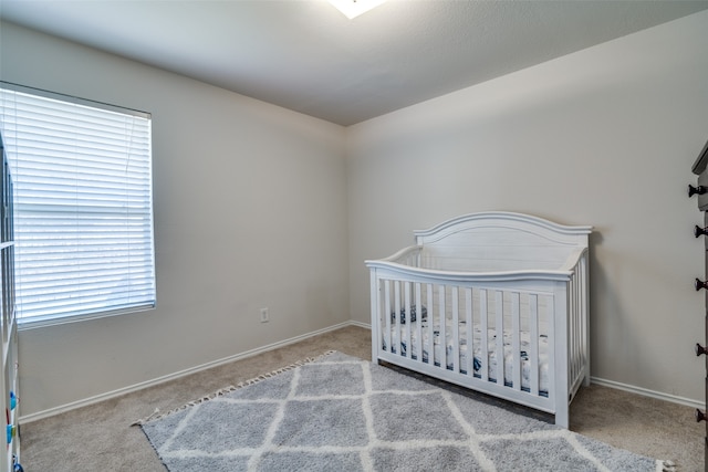 bedroom featuring light carpet and a crib