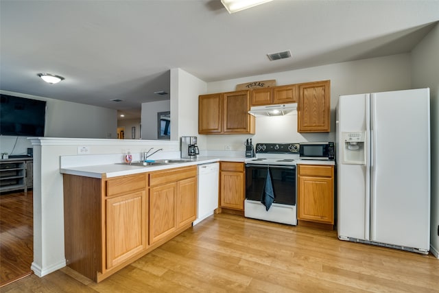 kitchen featuring light hardwood / wood-style flooring, white appliances, kitchen peninsula, and sink