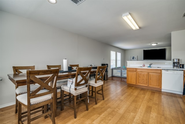 dining space featuring light wood-type flooring and sink