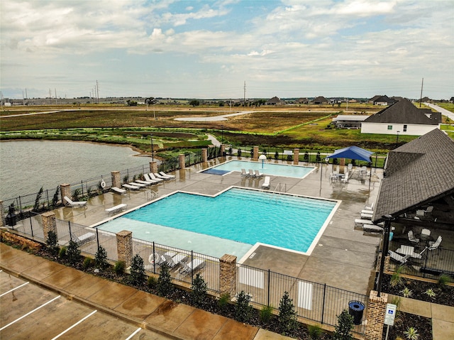 view of swimming pool with a patio and a water view