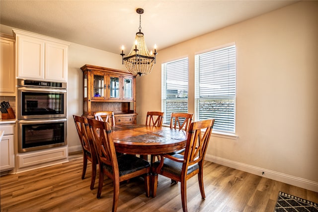 dining room featuring an inviting chandelier and light hardwood / wood-style flooring