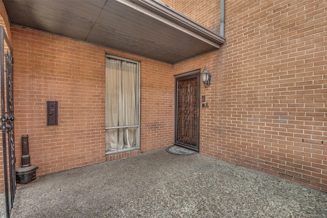 view of exterior entry with brick siding