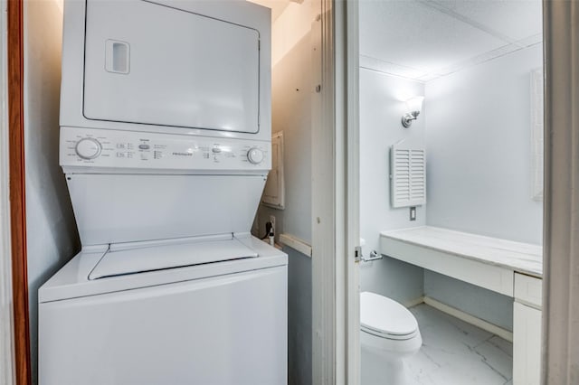 washroom with laundry area, marble finish floor, and stacked washer and clothes dryer