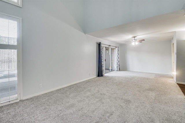 carpeted empty room featuring baseboards and a ceiling fan