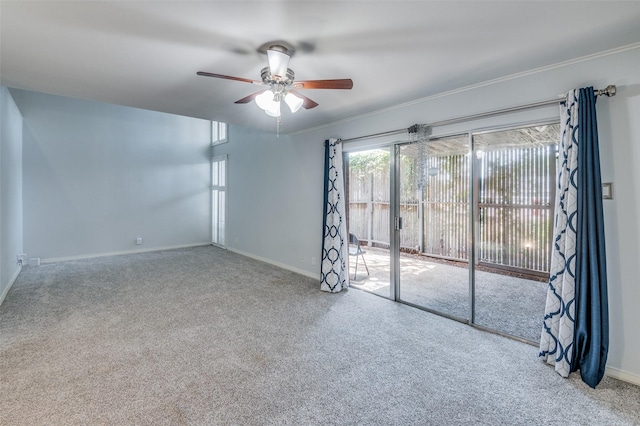 spare room featuring carpet, baseboards, ceiling fan, and crown molding