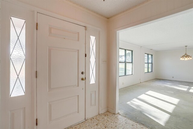 foyer entrance featuring a notable chandelier and a textured ceiling