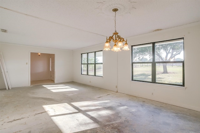 empty room featuring a notable chandelier and a textured ceiling