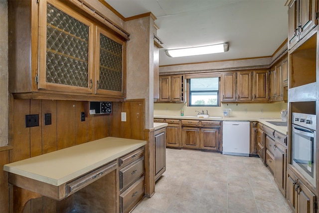 kitchen with light tile patterned flooring, stainless steel oven, sink, and white dishwasher