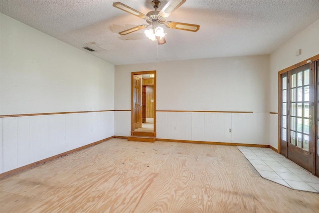 empty room featuring ceiling fan and a textured ceiling