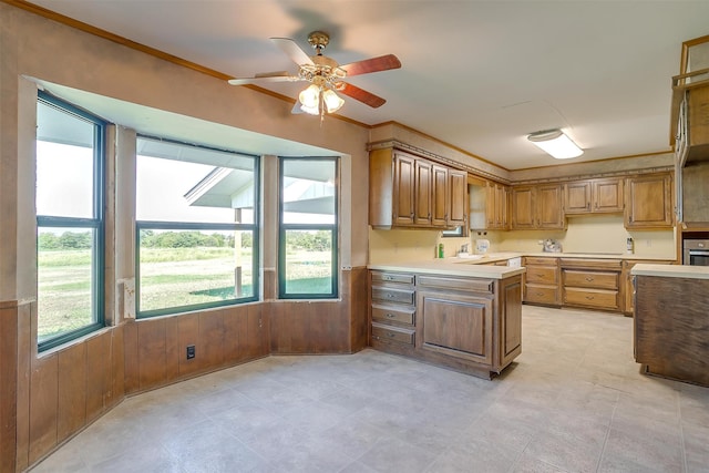 kitchen with ceiling fan, crown molding, oven, and light tile patterned floors