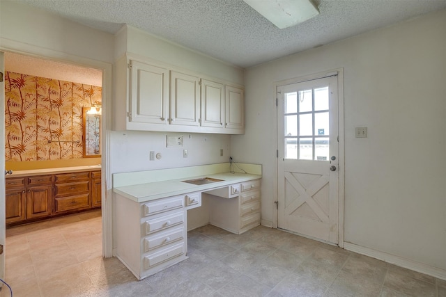 kitchen featuring light tile patterned flooring, a textured ceiling, and white cabinetry