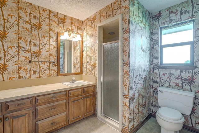 bathroom with toilet, an enclosed shower, vanity, and a textured ceiling