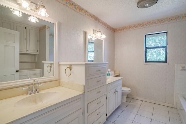 bathroom with toilet, a textured ceiling, tile patterned floors, and vanity