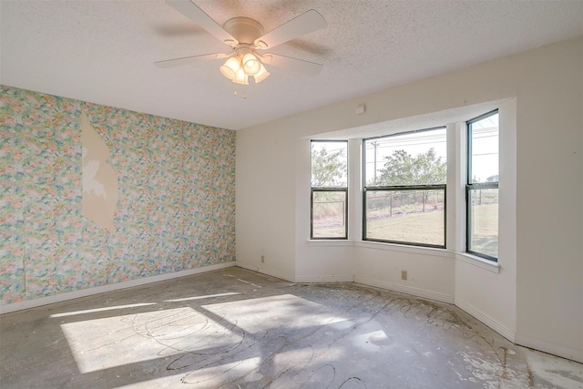 unfurnished room featuring ceiling fan and a textured ceiling