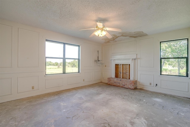 unfurnished living room with ceiling fan and a textured ceiling