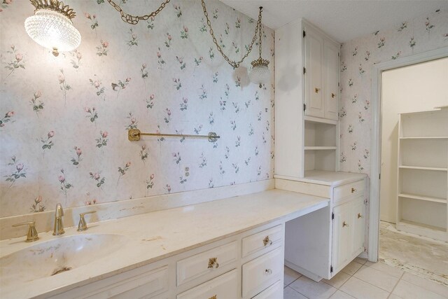 bathroom with tile patterned flooring, a textured ceiling, and vanity