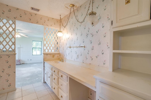 bathroom with a textured ceiling, ceiling fan, tile patterned flooring, and vanity