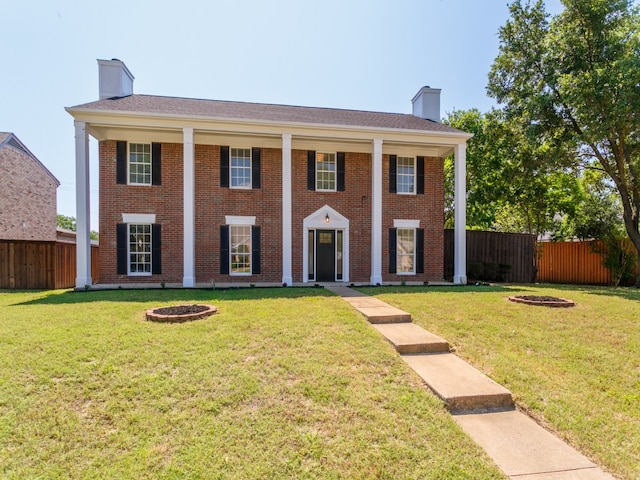 view of front facade featuring a front yard and an outdoor fire pit