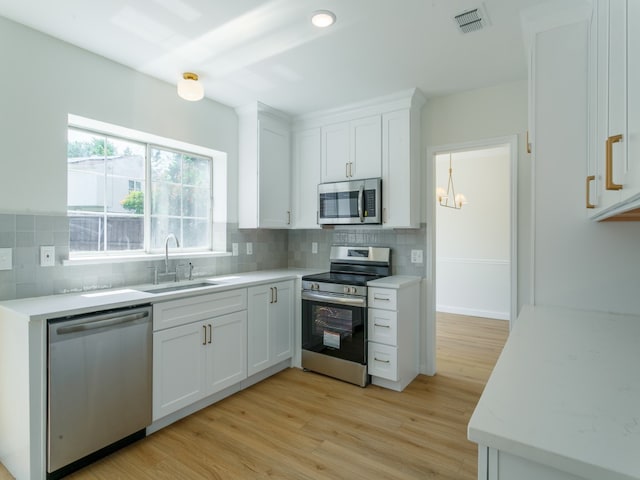 kitchen featuring sink, white cabinetry, light hardwood / wood-style flooring, and appliances with stainless steel finishes