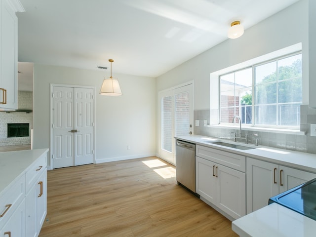 kitchen featuring light hardwood / wood-style floors, decorative backsplash, stainless steel dishwasher, and white cabinets