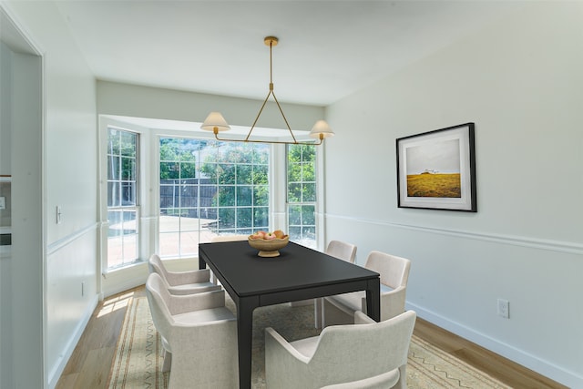 dining space featuring light wood-type flooring and a notable chandelier