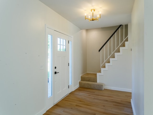 foyer entrance featuring light hardwood / wood-style flooring and a chandelier