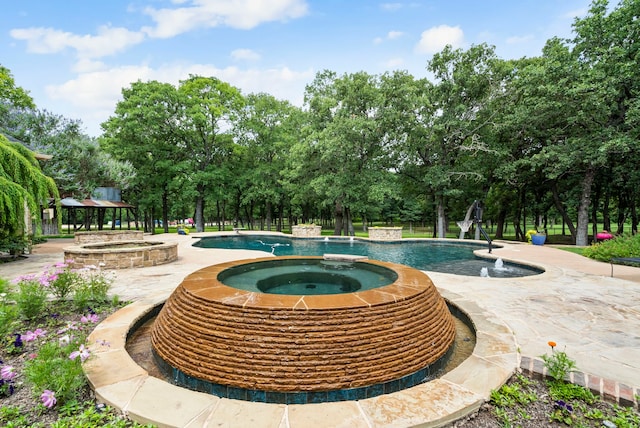 exterior space with an in ground hot tub, a patio area, and pool water feature