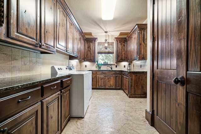 laundry room with sink, washer and clothes dryer, and cabinets