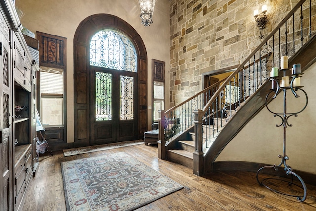 entryway featuring a towering ceiling, french doors, and wood-type flooring