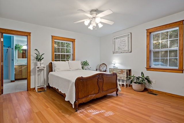 bedroom featuring ceiling fan, multiple windows, and light wood-type flooring