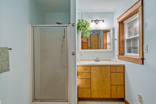 bathroom with tile patterned floors, vanity, and a shower with shower door