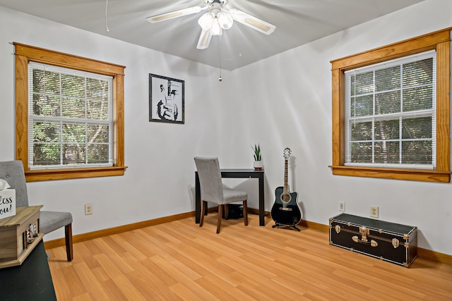 home office with light hardwood / wood-style flooring and ceiling fan