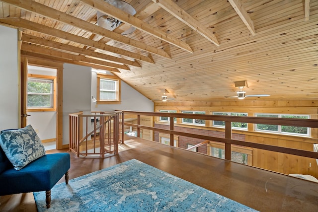 sitting room with ceiling fan, wood ceiling, wood walls, hardwood / wood-style floors, and lofted ceiling with beams