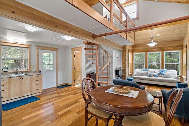 dining space with a wealth of natural light, light hardwood / wood-style floors, vaulted ceiling, and sink